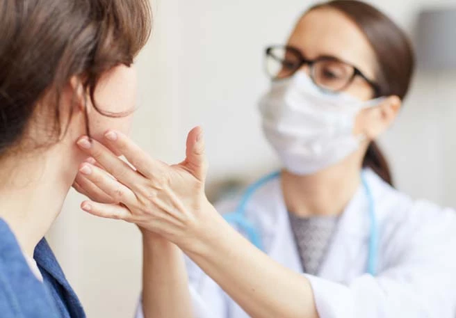 Ärztin prüft einseitige Halsschmerzen Ärztin prüft einseitige Halsschmerzen