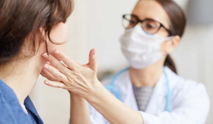 Ärztin prüft einseitige Halsschmerzen Ärztin prüft einseitige Halsschmerzen